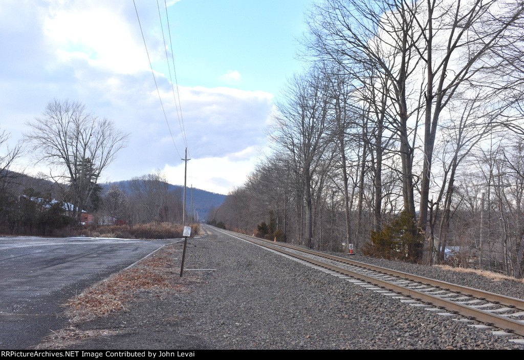 Viewed from the White House Station parking lot, we can see an example of the Raritan Valley Line west of Raritan being rural-the hills that surround the right of way